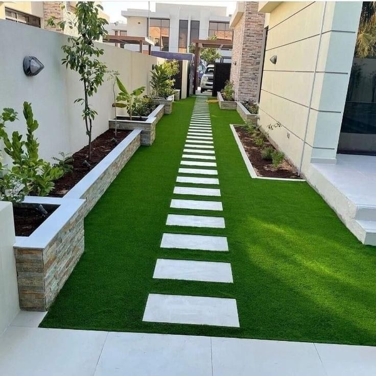 Beautiful residential garden designed by Daniya Nursery, a leading landscape company in Uttar Pradesh featuring lush green lawn and modern pathway design.